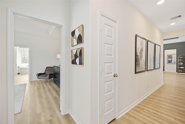 hallway featuring visible vents, recessed lighting, light wood-type flooring, and baseboards