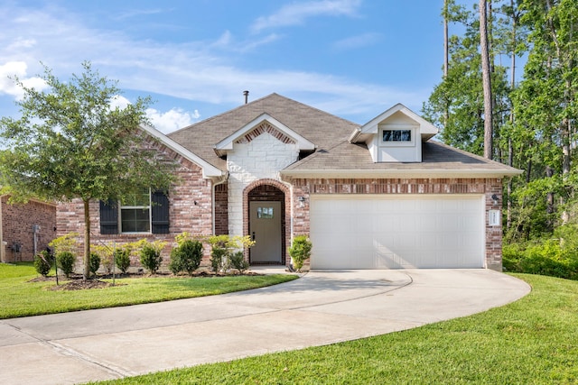 french provincial home featuring a front yard, driveway, roof with shingles, an attached garage, and brick siding