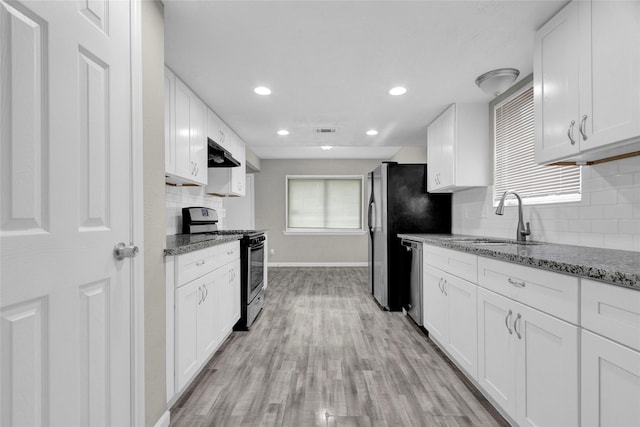 kitchen featuring visible vents, under cabinet range hood, stainless steel dishwasher, gas stove, and a sink