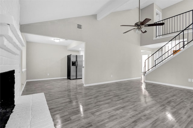 unfurnished living room with stairs, wood finished floors, a fireplace, and visible vents