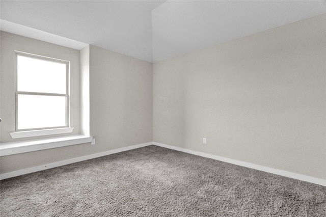 carpeted empty room featuring baseboards