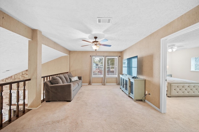 3130 Glade Springs Dr, Houston, TX 77339 - living area with visible vents, a textured ceiling, carpet, baseboards, and ceiling fan