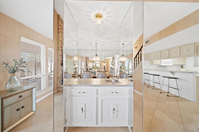 3130 Glade Springs Dr, Houston, TX 77339 - kitchen featuring light tile patterned floors, visible vents, white microwave, and light countertops