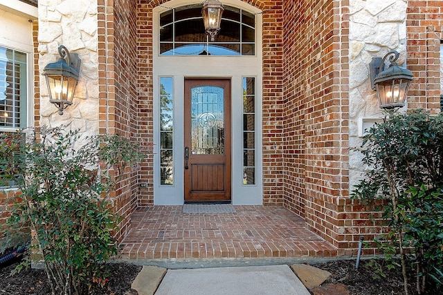 view of exterior entry with brick siding