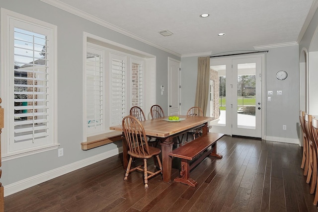 dining room featuring dark wood-style floors, crown molding, and baseboards