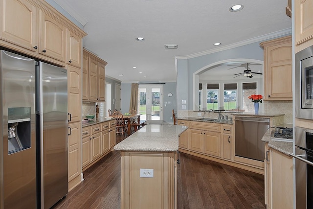 kitchen with dark wood finished floors, decorative backsplash, light brown cabinets, and appliances with stainless steel finishes