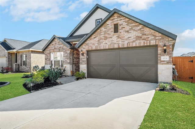 19710 Chianti Point Dr, Hockley, TX 77447 - view of front facade with brick siding, an attached garage, a front lawn, concrete driveway, and stone siding