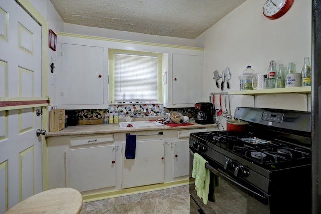 kitchen featuring gas stove, a textured ceiling, white cabinets, and light countertops