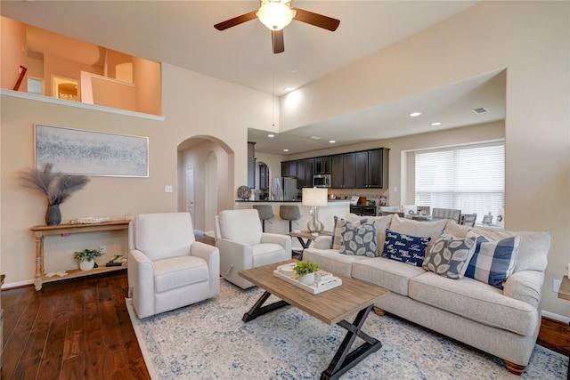 living room with baseboards, recessed lighting, wood finished floors, arched walkways, and a ceiling fan