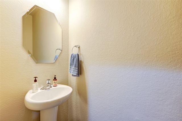 bathroom with a textured wall and a sink