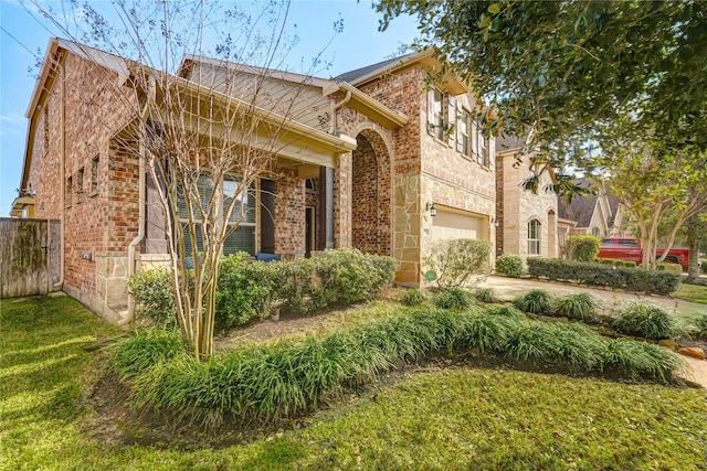 view of front of home with brick siding, concrete driveway, and fence