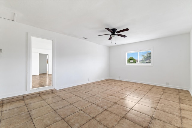 spare room featuring baseboards, visible vents, and ceiling fan