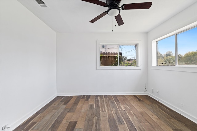 unfurnished room featuring visible vents, baseboards, and hardwood / wood-style flooring