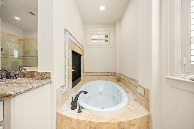 full bathroom featuring visible vents, a tiled fireplace, recessed lighting, a tub with jets, and a shower stall