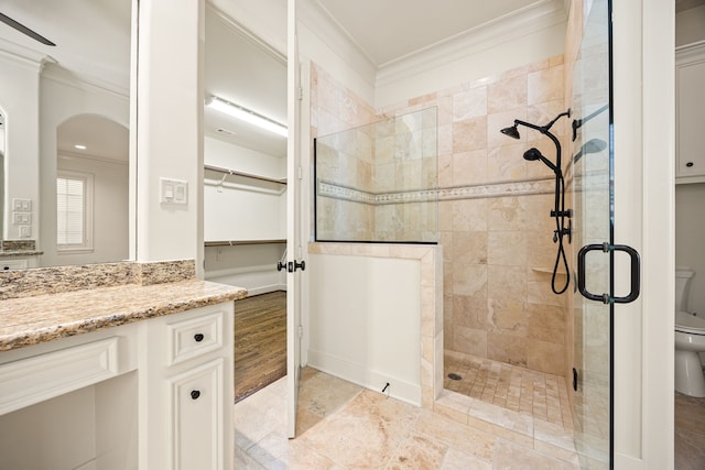 full bathroom featuring vanity, crown molding, toilet, and a walk in shower