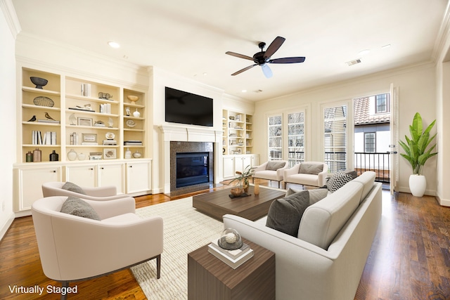 living area with a glass covered fireplace, crown molding, and wood finished floors