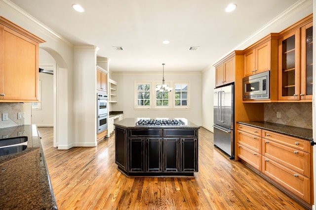 kitchen with crown molding, visible vents, appliances with stainless steel finishes, and a center island