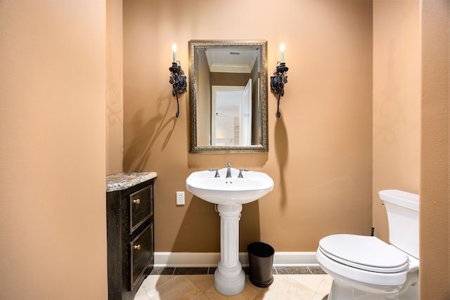 half bath featuring tile patterned flooring, toilet, and baseboards