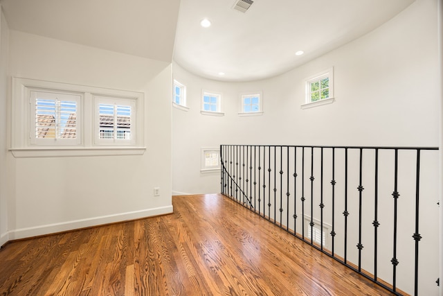 empty room featuring recessed lighting, wood finished floors, visible vents, and baseboards