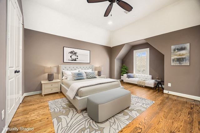 bedroom with vaulted ceiling, light wood-style flooring, baseboards, and ceiling fan