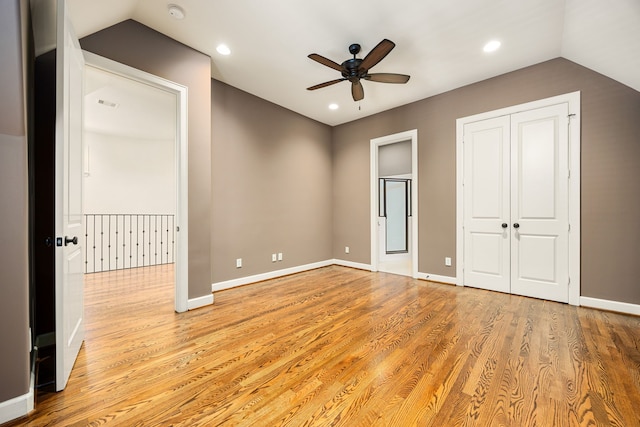 unfurnished bedroom featuring light wood finished floors, recessed lighting, baseboards, and vaulted ceiling