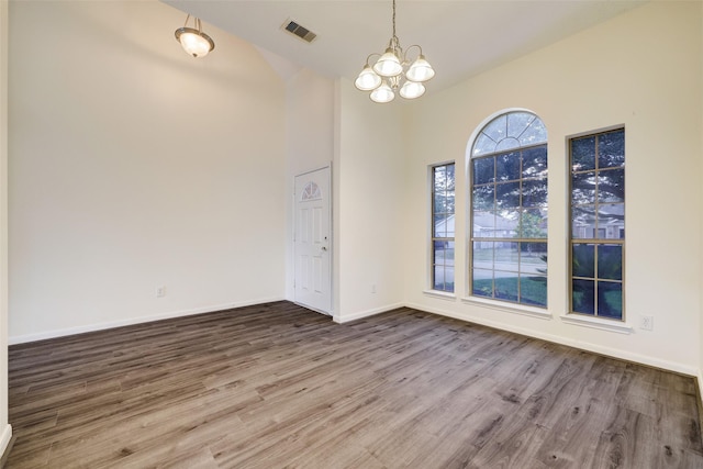 entryway featuring a chandelier, visible vents, baseboards, and wood finished floors