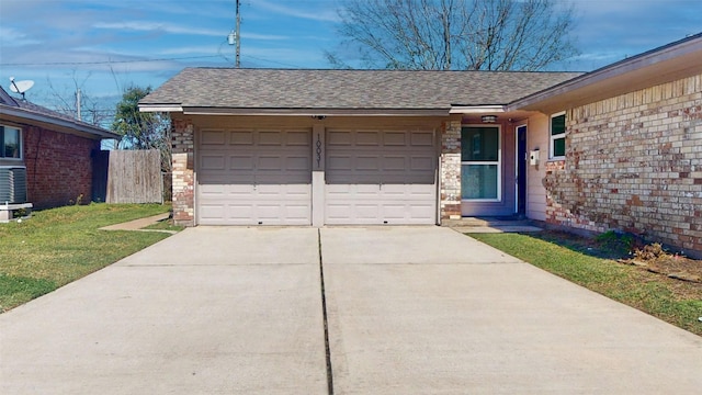 garage featuring driveway and fence