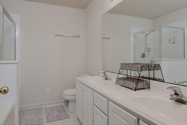 full bathroom featuring toilet, tiled shower, baseboards, and a sink