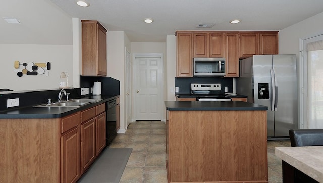 kitchen with dark countertops, visible vents, appliances with stainless steel finishes, and a sink