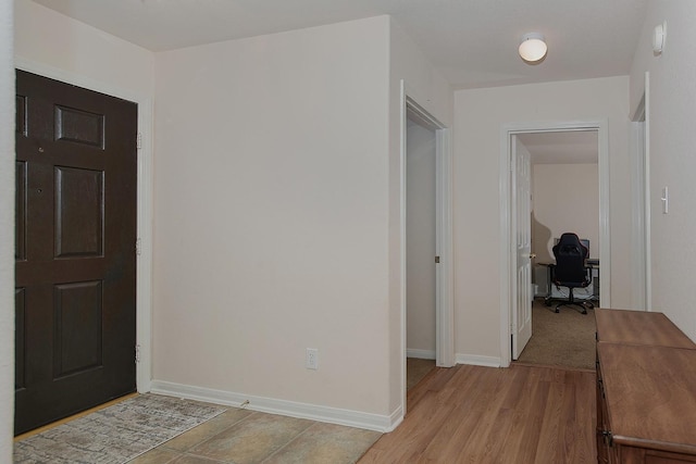 entryway with baseboards and light wood-style floors