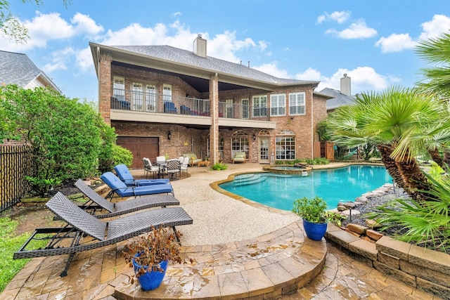 view of swimming pool with fence, a pool with connected hot tub, and a patio area