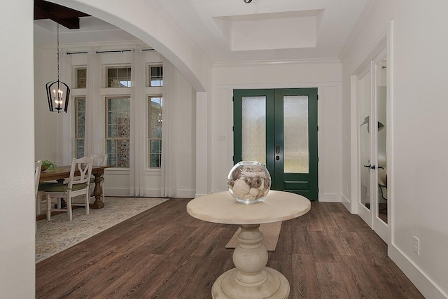 foyer with dark wood finished floors, french doors, arched walkways, an inviting chandelier, and baseboards