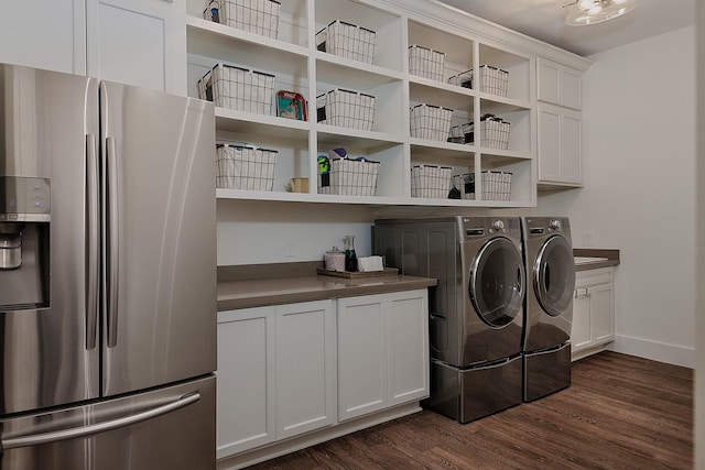 laundry area with dark wood finished floors, washer and dryer, cabinet space, and baseboards