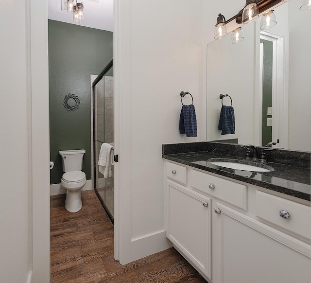 full bathroom with vanity, a shower stall, toilet, and wood finished floors