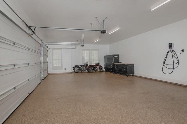 garage with a garage door opener and baseboards