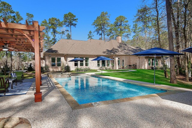 pool featuring a patio area and a lawn