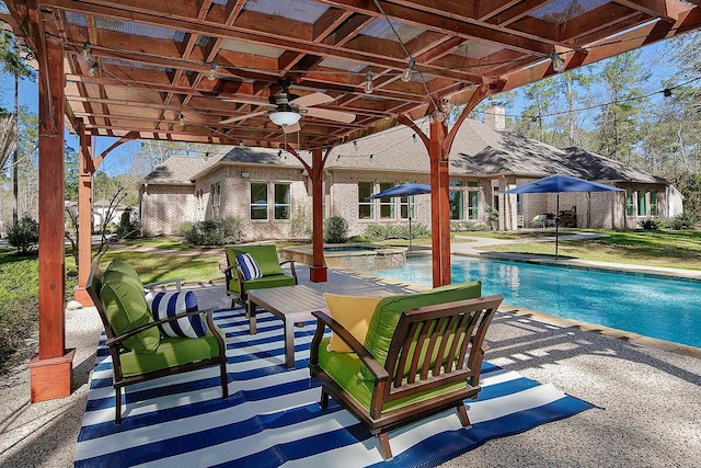 view of swimming pool with a pool with connected hot tub, a ceiling fan, and a patio area