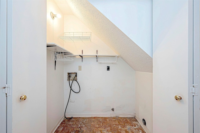 washroom featuring laundry area, hookup for a washing machine, a textured ceiling, and baseboards