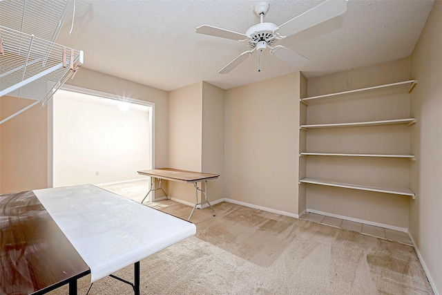 unfurnished office featuring ceiling fan, carpet, baseboards, and a textured ceiling