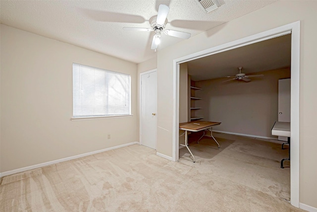 unfurnished bedroom featuring visible vents, baseboards, carpet flooring, a textured ceiling, and a ceiling fan