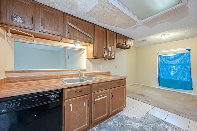 kitchen featuring dishwasher, light carpet, light tile patterned flooring, a textured ceiling, and a sink