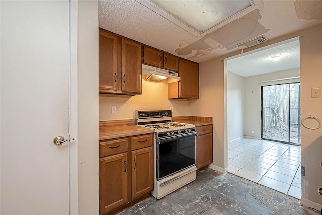 kitchen featuring visible vents, under cabinet range hood, a textured ceiling, brown cabinetry, and white gas range