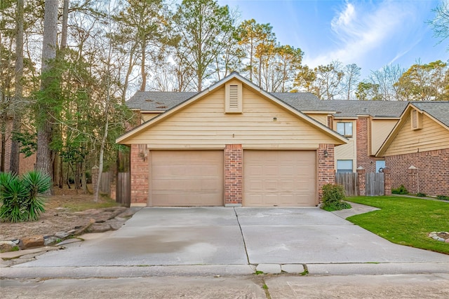 view of front of property featuring a garage, brick siding, a front yard, and fence