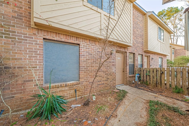 exterior space featuring fence and brick siding