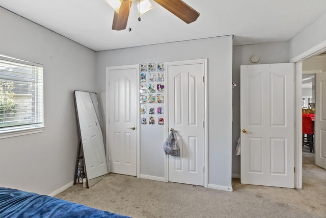 unfurnished bedroom with light carpet, ceiling fan, and baseboards