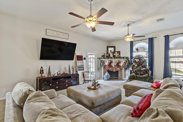 living area with baseboards, carpet, visible vents, and ceiling fan