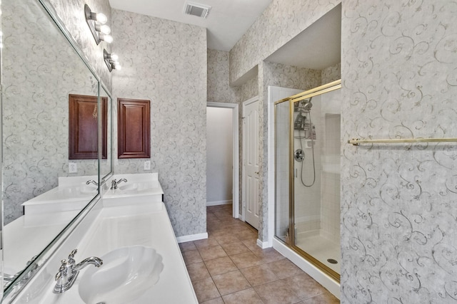 bathroom featuring visible vents, wallpapered walls, a stall shower, a sink, and tile patterned flooring