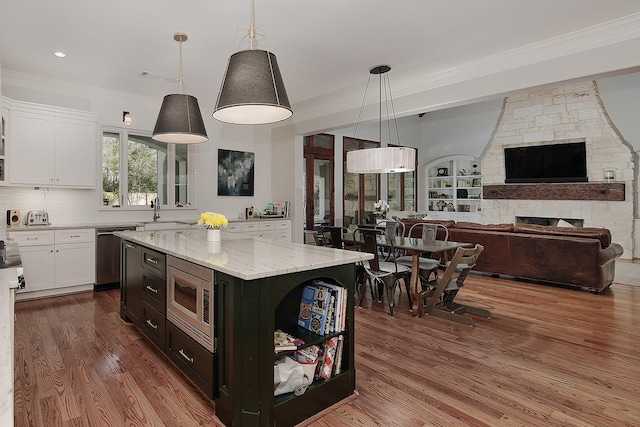 kitchen featuring light stone countertops, a sink, dark wood-type flooring, white cabinets, and appliances with stainless steel finishes