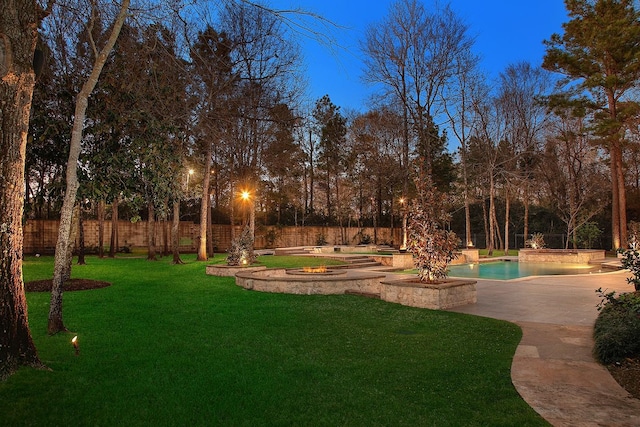 view of yard featuring a patio area, a fenced in pool, a fenced backyard, and an outdoor fire pit