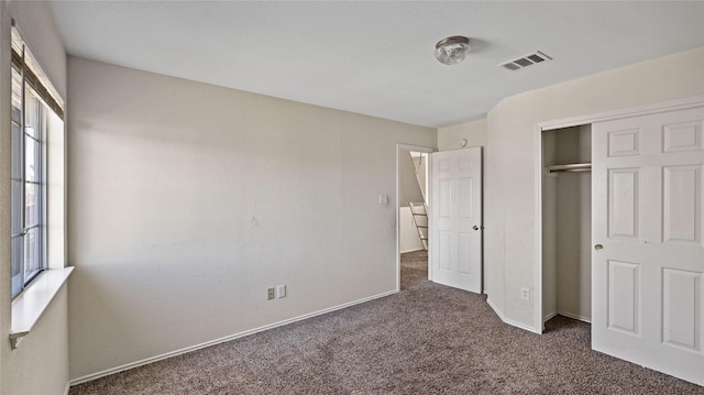 unfurnished bedroom featuring a closet, baseboards, visible vents, and carpet floors